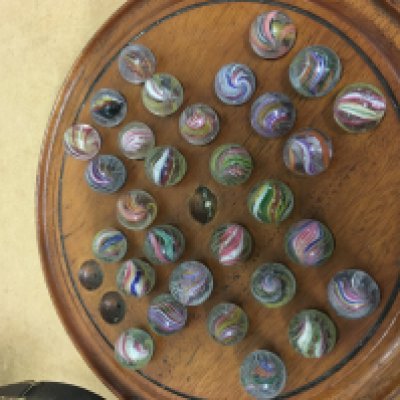 A solitaire board with two marbles missing.