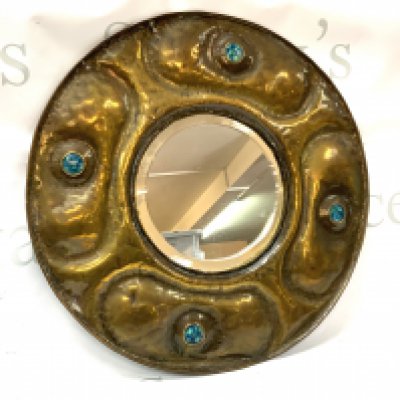 A hammered arts and crafts brass mirror inset with Ruskin style panels. 38cm.
