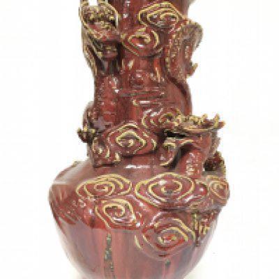 A large Chinese Sang De Boeuf Vase with relief dragons and cloud decoration, 56cm tall. This lot cannot be posted