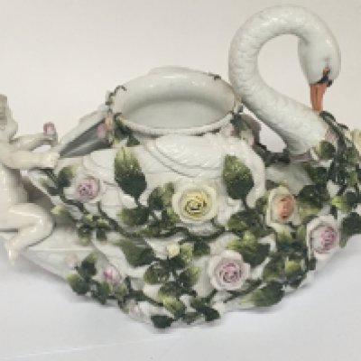 A German late 19th century porcelain jardiniere ornament in the form of a swan encrusted with raised flowers and putti. under-glazed blue marks to the base some small chips to the foliage. See images. 30cm wide Hight 22cm. NO RESERVE