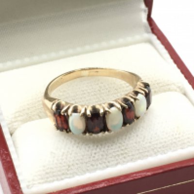 A 9 carat gold opal and garnet ring p, size O/P. 2.9g Postage category a