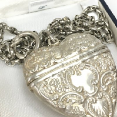 A silver heart pendant locket and chain , postage category a