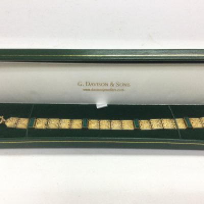 A yellow metal gold bracelet set with green stones, approx 13.9g. Shipping category A.