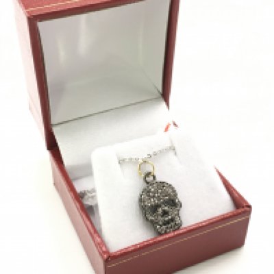A diamond set skull pendant, in silver and silver gilt on a silver chain. Diamonds 0.40Ct