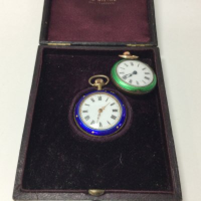Two enamelled pocket watches in a case.