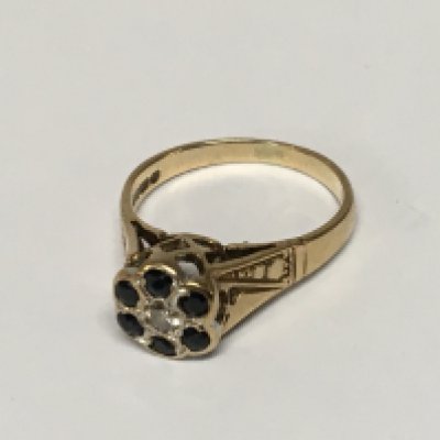 A 9carat gold ring set with a pattern of blue sapphire and with a small central diamond. Weight 2.9g