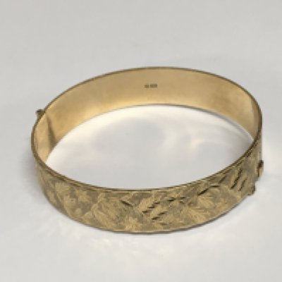 A 9carat gold bangle with bright cut pattern hinged and closing clasp good condition weight 24g
