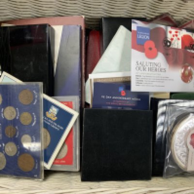 A basket of various coinage including some proof sets.