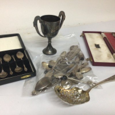 A collection of silver comprising a silver apostle spoon in a case a cased set of silver coffee spoons a trophy cup loose spoons and silver handled cutlery and a Continental sugar caster.