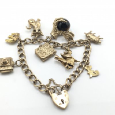 A 9ct gold charm bracelet with numerous charms. Total weight 26.9g