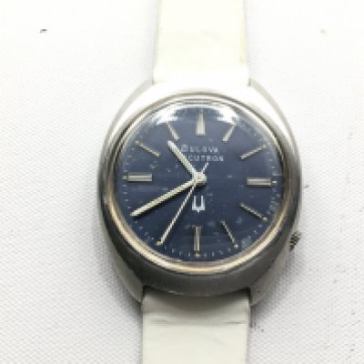 A Bulova Accutron blue dial wrist watch with white leather strap. Seen running Postage b