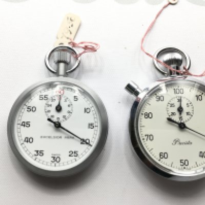 Two stop watches one by Excelsior park and other precista. Both seen running.