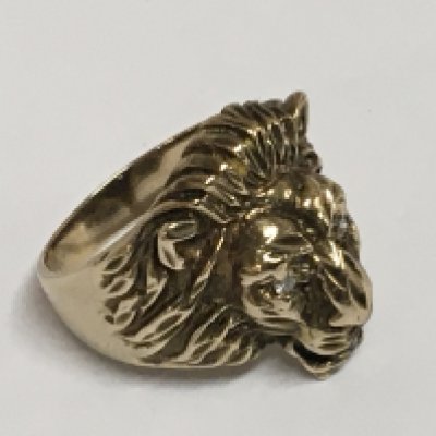 A gold 9carat unmarked ring in the form of a lions head the eyes set with diamonds. Weight 5.5g