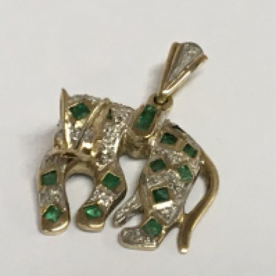 A 9carat gold pendant in the form of a lion set with small diamond and emerald.
