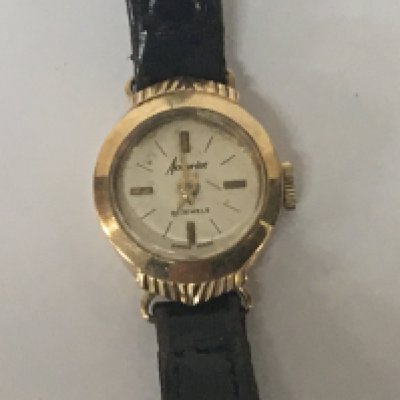 A 9carat gold ladies watch with a leather strap.