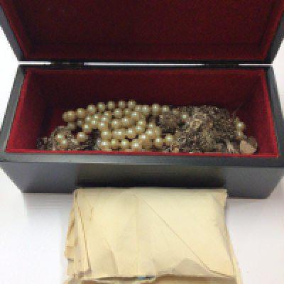 A small box of costume jewellery including some silver items and other pieces of jewellery.
