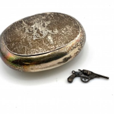 A hallmarked silver tobacco box together with a small silver gun charm. (A)