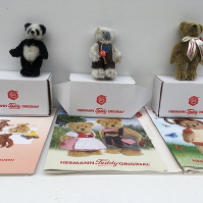 Three boxed Herman minature teddies featuring a Panda bear from 2005 a light grey bear from 2012 and a golden brown bear from 2014. Includes associated magazines. No reserve