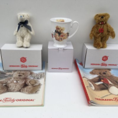 Two boxed minature Herman teddy bears from 2007 white and 2010 golden brown. Also includes a Herman&#2013266057۪s mug and some magazines. No reserve.