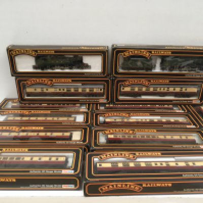 A collection of boxed 00 gauge model railway pieces featuring 2x locomotives and 9 coaches. No reserve.