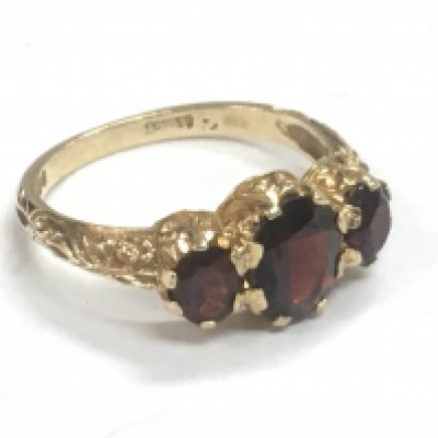 A 9 carat gold Edwardian three stone garnet ring, 3g. Size N Postage category A