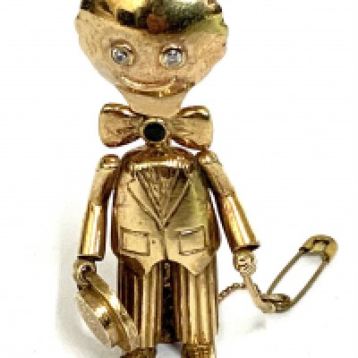 A vintage heavy 9ct gold brooch in the form of a Golly Set with white cut stone eyes and a sapphire within the bow tie. 26.67g (5.6cm). Postage category A.