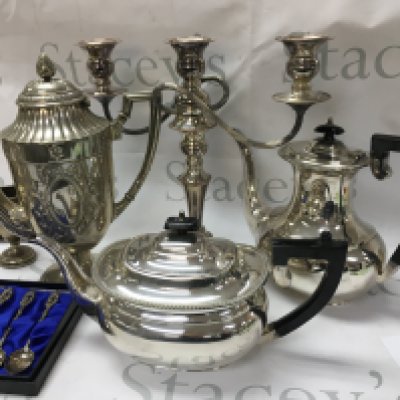 A box containing silver plated ware various including tea pot coffee pot muffin dish set of spoos .