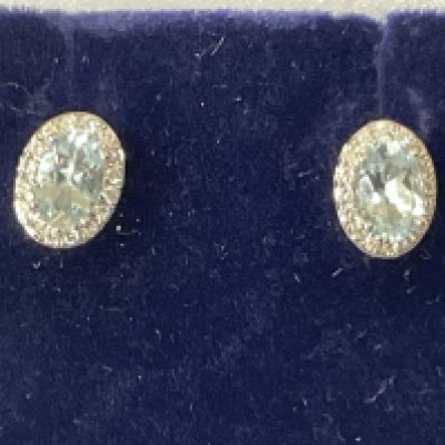 Pair of 9ct white gold oval aquamarine and RBC diamond cluster studs, boxed. Aquamarine 0.60ct. Diamonds 0.13ct. Postage category A.