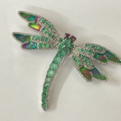 Large silver dragonfly brooch and pendant (combined) set with round emeralds, diamonds and round ruby eyes, with enamelled wingtips in colours of purple, green and orange. Emeralds 3.50ct approx. Diamonds 1.12ct. Rubies 0.20ct approx. Postage category A.