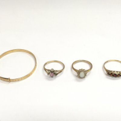 A collection of gold rings set with different stones including opal and an unmarked gold coloured bangle. 6g total. Postage B