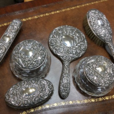 A silver dressing table set with tidy jars . Postage category B