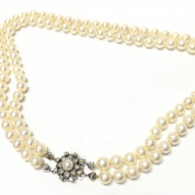 A double strand of cultured pearls with a 14ct gold, clasp set with diamond . Postage category B