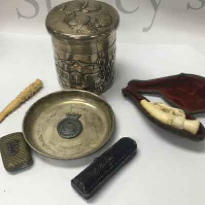 A silver string box a silver dish a collection of smoking items .