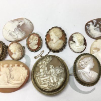 A collection of cameos , some mounted in silver and yellow metal . Postage category a