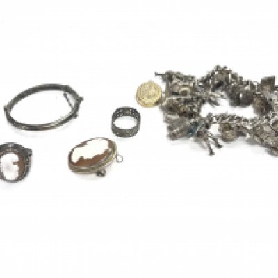 A collection of silver items including a silver charm bracelet cameo ring and broach etc Postage B