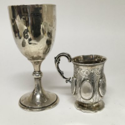 A Victorian silver christening mug no with raised ovals no personal inscriptions London hallmarks and a silver trophy cup.