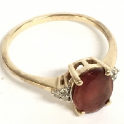 A 9 carat gold ring wet with an oval cornelian stone and small diamonds. Size S. 2.7g Postage category A
