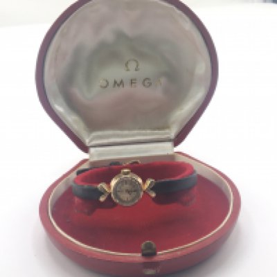 A gold cased Vintage ladies Omega watch with leather strap manual wind.and Omega clasp with box