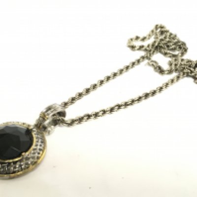A silver chain with a black stone pendant. Postage cat A