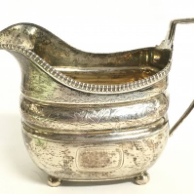 An early 19th century silver hallmarked cream jug. Postage category B