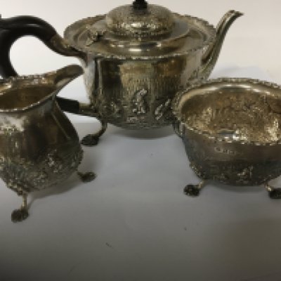 A Three piece silver tea set repousse decorated with game birds pheasant and rabbits mixed hallmarks Chester and Birmingham. 684g approximately