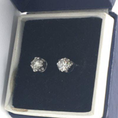 A pair of brilliant cut diamond stud earrings approximately 0.15 a carat each set in gold.