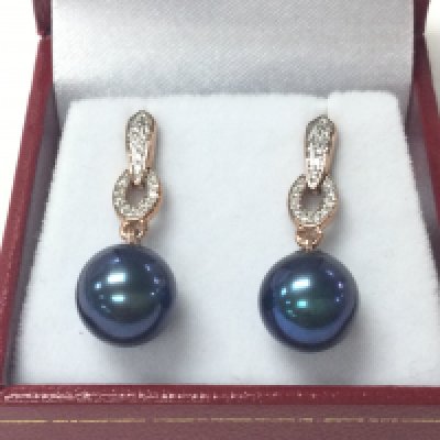 A pair of 9ct rose gold drop earrings set with purple / blue cultured pearls and diamond drop with box. 0.16ct diamonds approx.