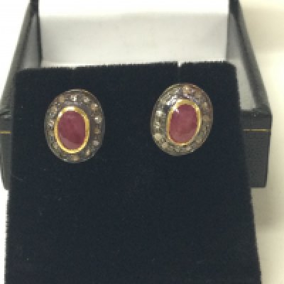 A pair of oval ruby and R/C diamond halo studs in gold plated silver. Ruby 0.28ct and 0.15ct diamonds approx. Postage B