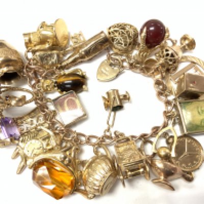 A 9ct gold charm bracelet with approx 82.2g. (25 charms) Postage category A.