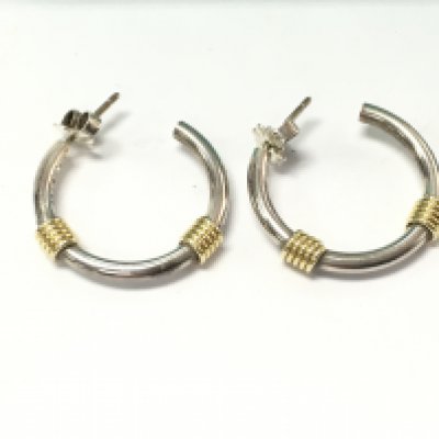 A pair of tiffany and Co silver and 18ct gold hoop earrings with box and pouch. Postage B