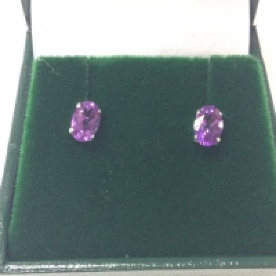 A pair of platinum studs set with oval amethysts with silicon capped butterflies. Amethysts approx 0.80ct. Postage A