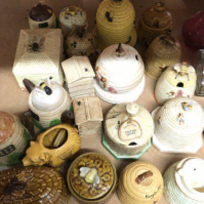 A collection of ceramic honey pots preserve jars and covers.