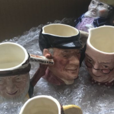A Collection of miniature character jugs .