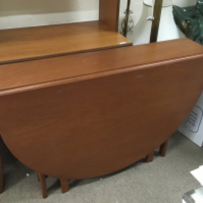 A drop leaf teak table, 74cm tall, 154cm wide.